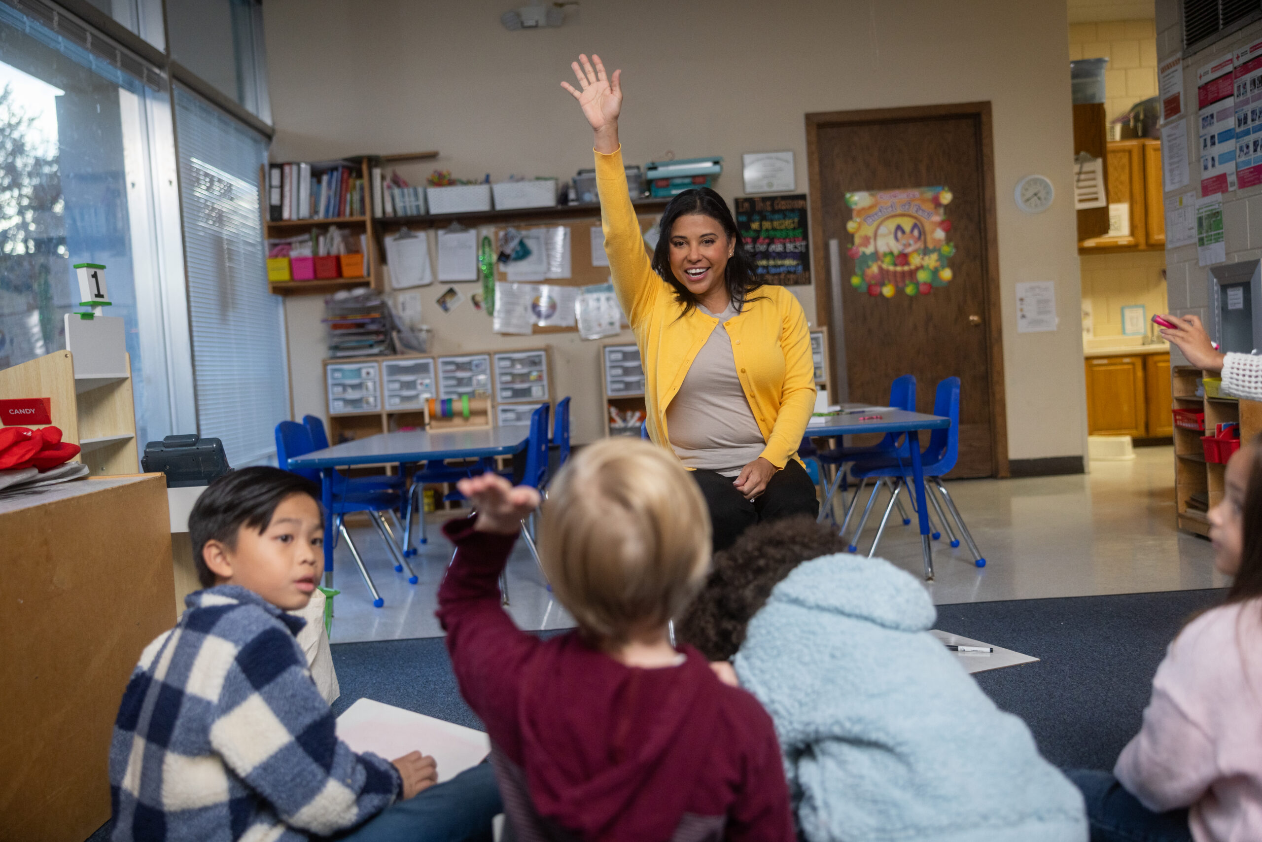 Teacher raising her hand in front of students