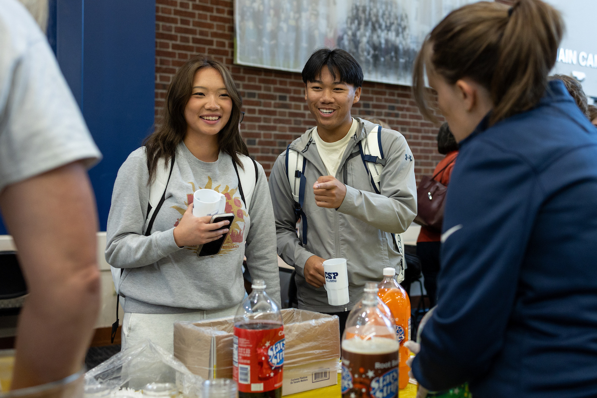 Two college students being served an ice cream float